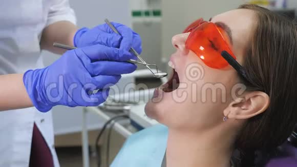 年轻女子在牙医的牙科椅上接受预防性检查牙齿护理概念视频的预览图