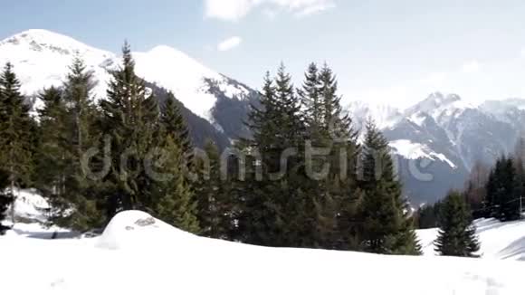 有小木屋和松树的雪山视频的预览图