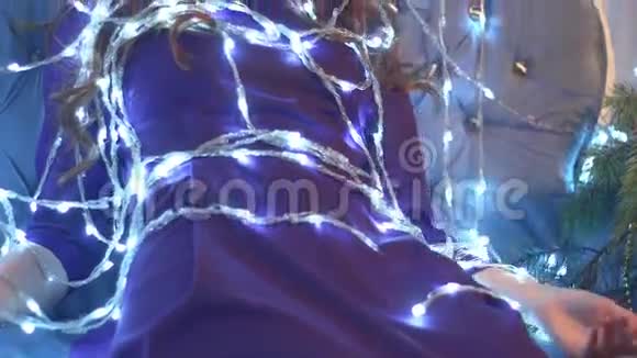 美丽的红发女孩笼罩在一个发光的圣诞灯泡视频的预览图