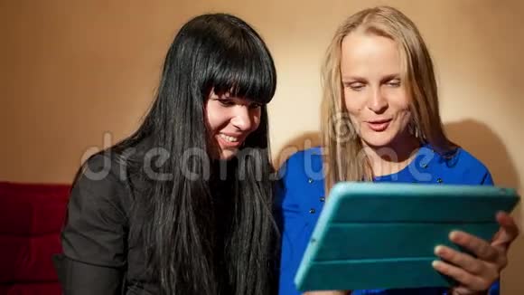 两个年轻的女人在读平板电脑视频的预览图