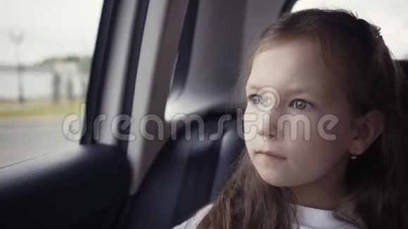 阳光明媚的一天小女孩从车窗往外看视频的预览图