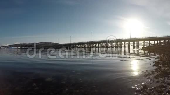 挪威北部古老的木桥平静的海浪和灿烂的阳光视频的预览图