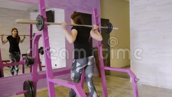 年轻漂亮的女孩在健身房用哑铃做运动视频的预览图