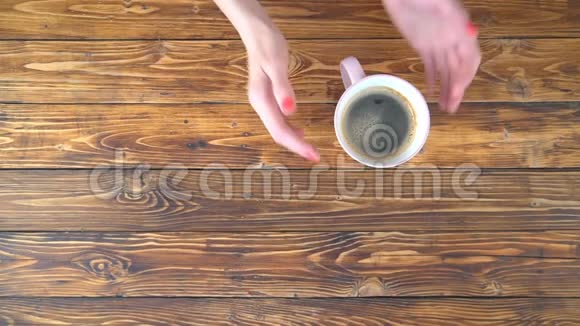 可爱的一对夫妇手里拿着一杯咖啡放在木制背景上视频的预览图