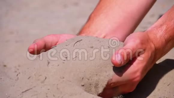 沙从男性手在海滩上缓慢运动男人手里的脏沙视频的预览图