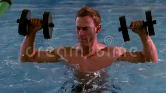 肌肉男在游泳池里用泡沫哑铃工作视频的预览图