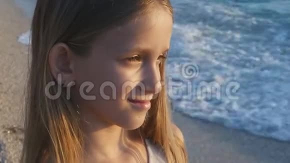 日落海滩上的儿童嬉戏看海浪的儿童沙滩上的女孩肖像视频的预览图