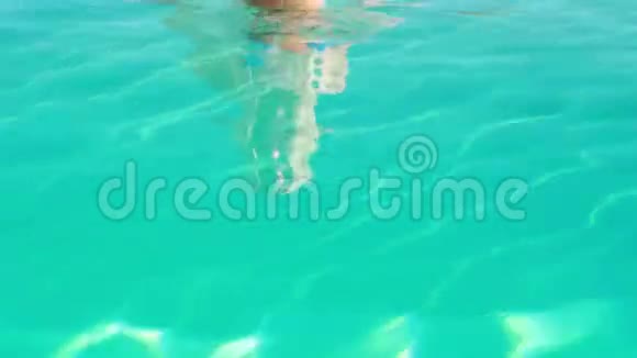 穿着蓝色比基尼的金发美女在游泳池里尽情放松对着镜头微笑视频的预览图