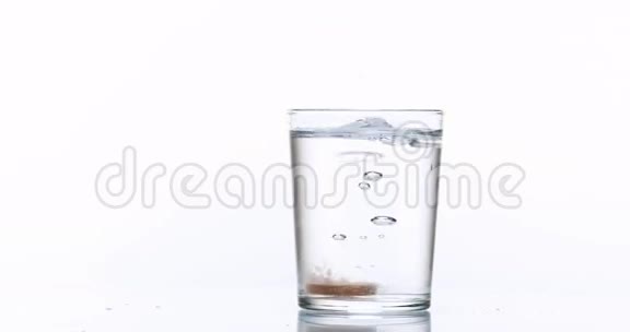 片剂或维生素在白色背景下掉落并溶解成一杯水视频的预览图