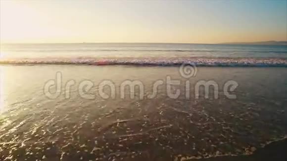 日落时到达海滩的海波照片视频的预览图