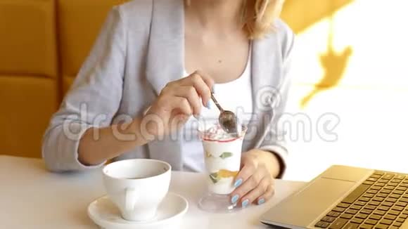 漂亮的年轻女人在咖啡馆吃美味的甜点视频的预览图