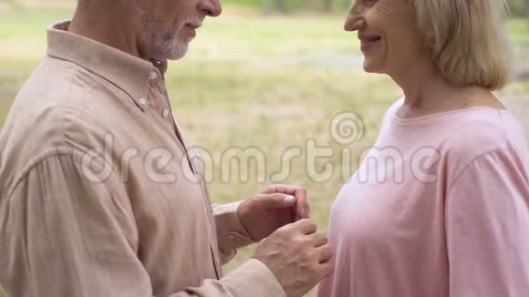 快乐浪漫的情侣在户外约会时牵手祖父母爱视频的预览图