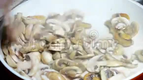 盘上烤的新鲜蘑菇把蘑菇放锅里煎视频的预览图