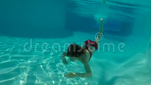 美女慢动作与年轻女子在游泳池水下游泳视频的预览图