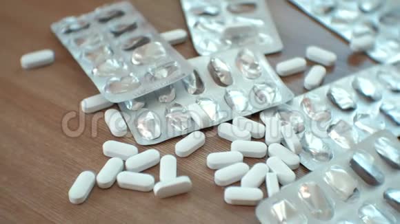 药片和白色药丸的水泡在桌子上特写镜头视频的预览图