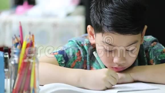亚洲可爱的男孩独自在家做作业视频的预览图