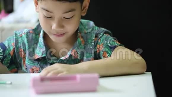 亚洲可爱的男孩独自在家做作业视频的预览图