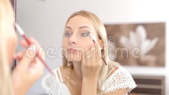 美女化妆美丽的女孩照镜子视频的预览图