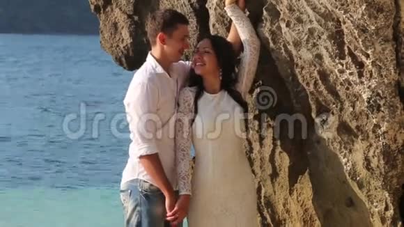 新郎新娘站在悬崖边的浅水中拥抱视频的预览图