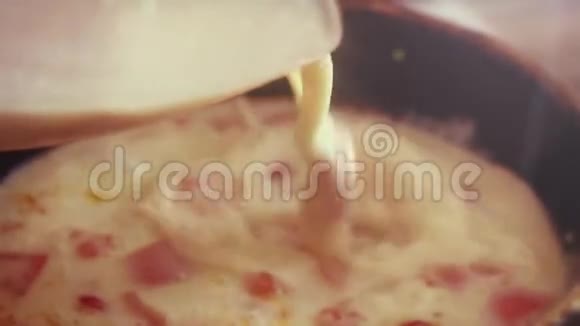 用番茄和火腿在平底锅中缓慢地倒入和烹饪煎蛋卷1920x1080视频的预览图
