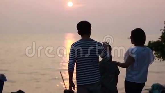亚洲家庭看日落海背景视频的预览图