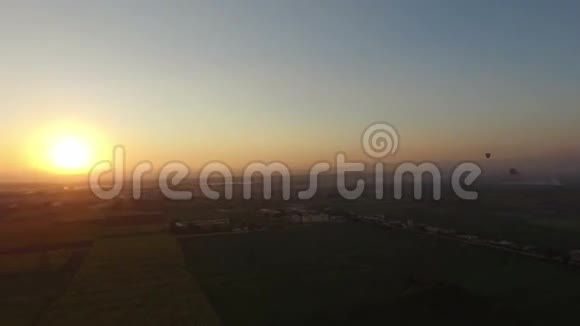 日出时热气球飞过卢克索的田野视频的预览图