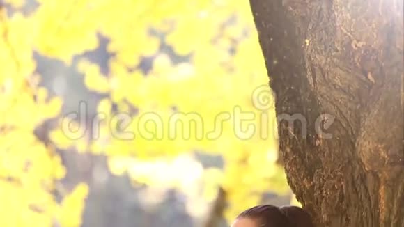 一位深褐色头发的美女靠在树上唱歌视频的预览图