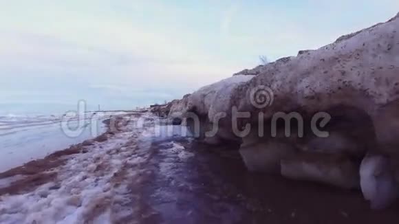 冬季海滨海滩上的冰冻岩石池视频的预览图