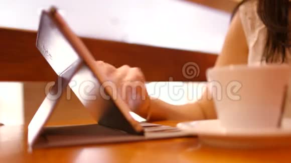 女人在咖啡馆的平板电脑上写了一条信息视频的预览图