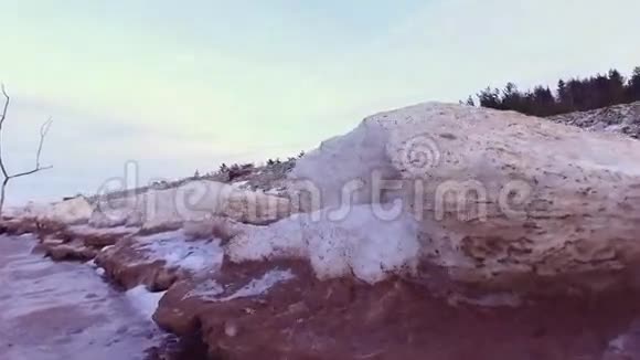 冬季海滨海滩上的冰冻岩石池视频的预览图