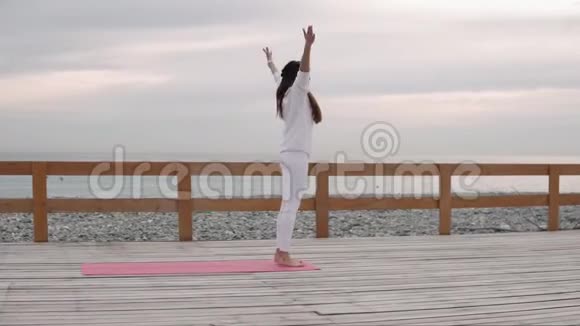 在海滩上练习瑜伽的健身妇女视频的预览图