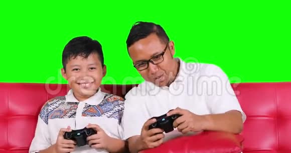 男孩和父亲一起玩电子游戏视频的预览图