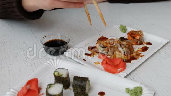 日本餐馆里的女人吃寿司卷配筷子视频的预览图