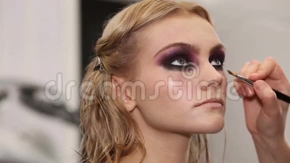 专业化妆师把化妆品放在模特脸上视频的预览图