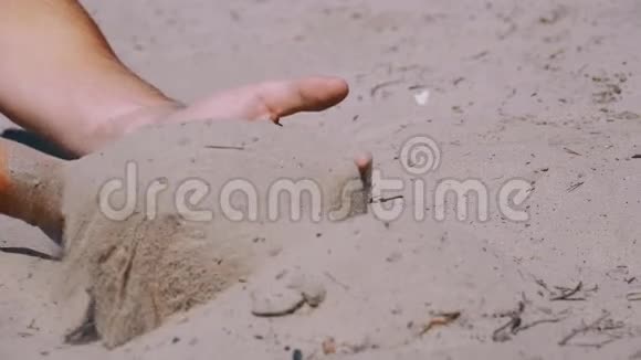 男性手在沙滩上慢慢地落沙子男人手里的脏沙视频的预览图