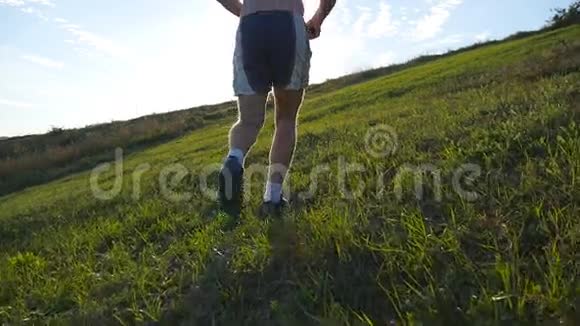 年轻人跑过青山越过蓝天背景男性运动员在日落时在大自然中慢跑体育运动员视频的预览图
