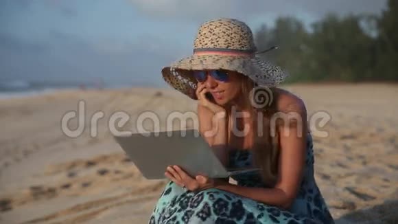 微笑的女人在海滩上用手机聊天视频的预览图