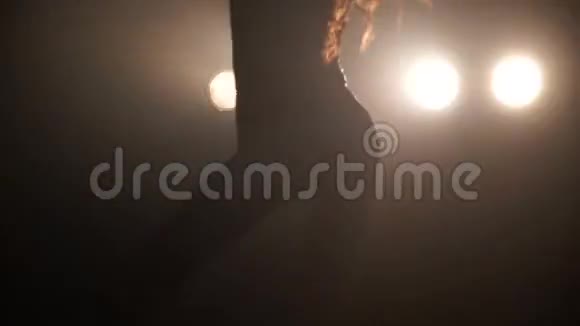 一个女孩在灯光的背景下热情地跳舞的剪影视频的预览图
