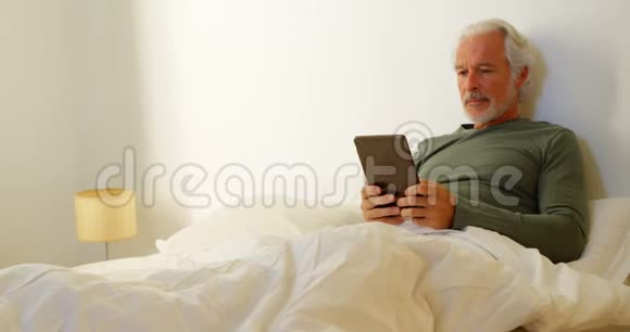 卧室4k的老人在床上使用数码平板电脑视频的预览图