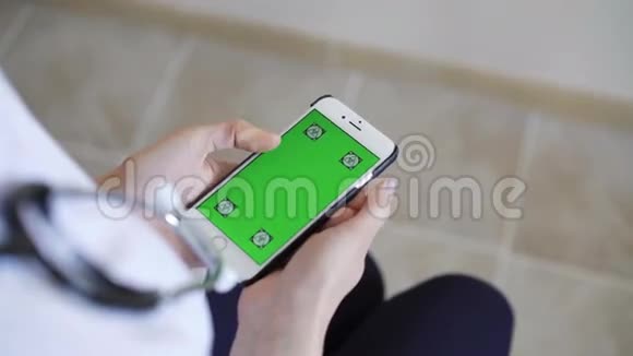 女医生展示绿色屏幕智能手机视频的预览图
