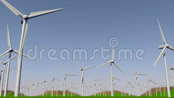 在白天摄像机从左到右通过一组涡轮机在绿色的田野上形成一个风力农场视频的预览图