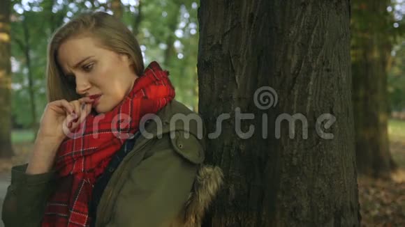 秋天公园里悲伤的年轻美丽的女孩视频的预览图