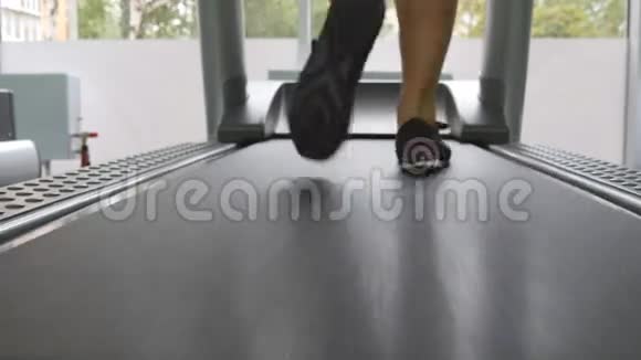 女腿在健身房跑步机上跑步年轻女性在有氧运动中锻炼穿运动鞋的女孩脚视频的预览图