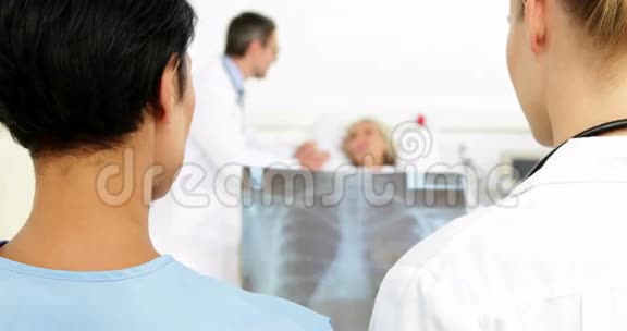 医生在病床上病人面前讨论x射线视频的预览图
