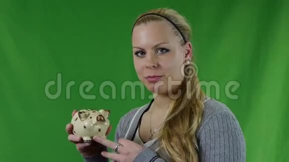 女人把硬币放在猪银行里视频的预览图