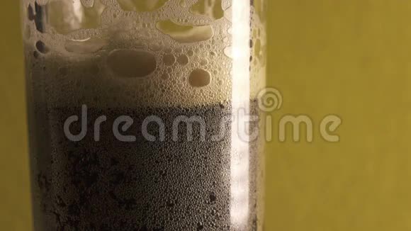 棕色泡沫饮料克瓦斯或啤酒倒在玻璃杯里一小瓶泡沫破裂手拿走一个玻璃杯视频的预览图