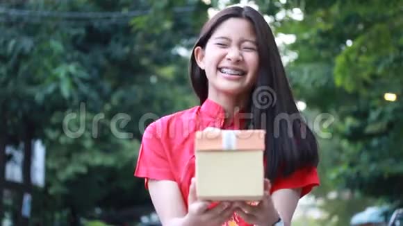 泰国少年漂亮女孩穿着中国服装新年快乐打开盒子礼物微笑和非常高兴视频的预览图