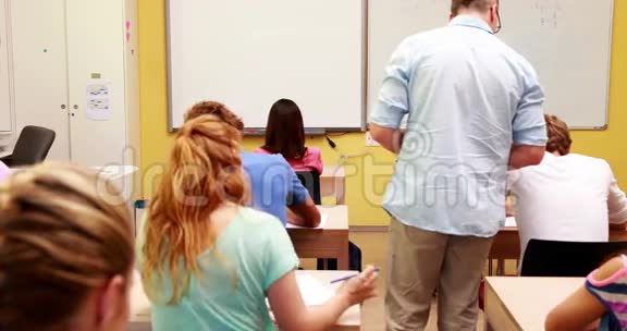 在考试期间讲师在他的课堂上走来走去视频的预览图