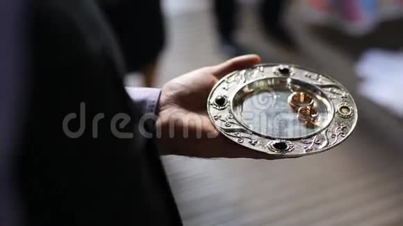 在教堂的金盘上合上豪华的戒指婚礼仪式视频的预览图