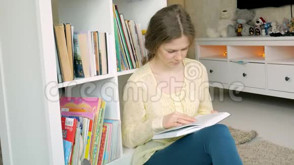 年轻女子在寻找一本书学生选择书架图书馆女性从图书馆的书架上拿书视频的预览图